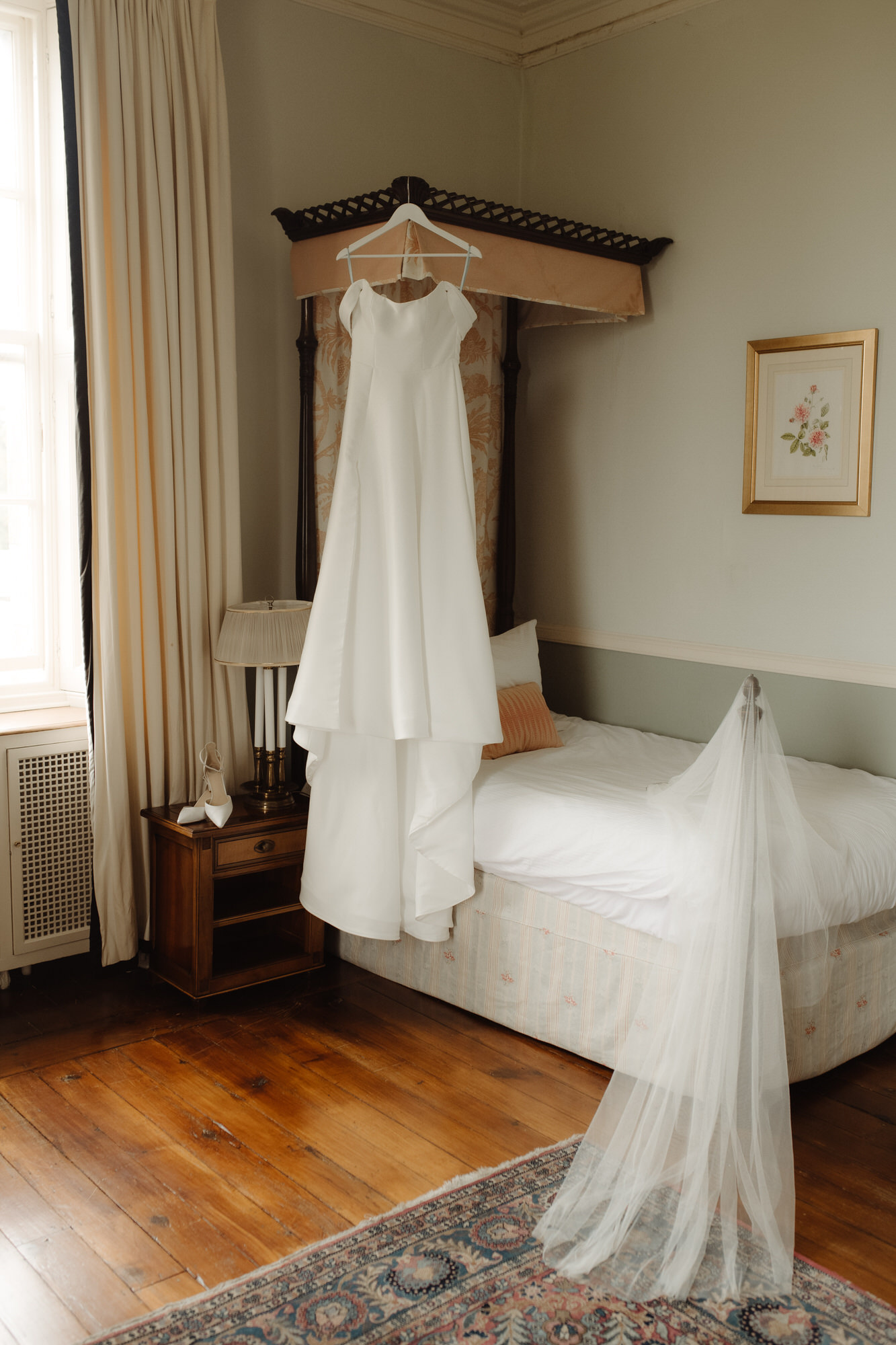 Wedding dress and veil hang on a poster frame bed at Kinmount House wedding.