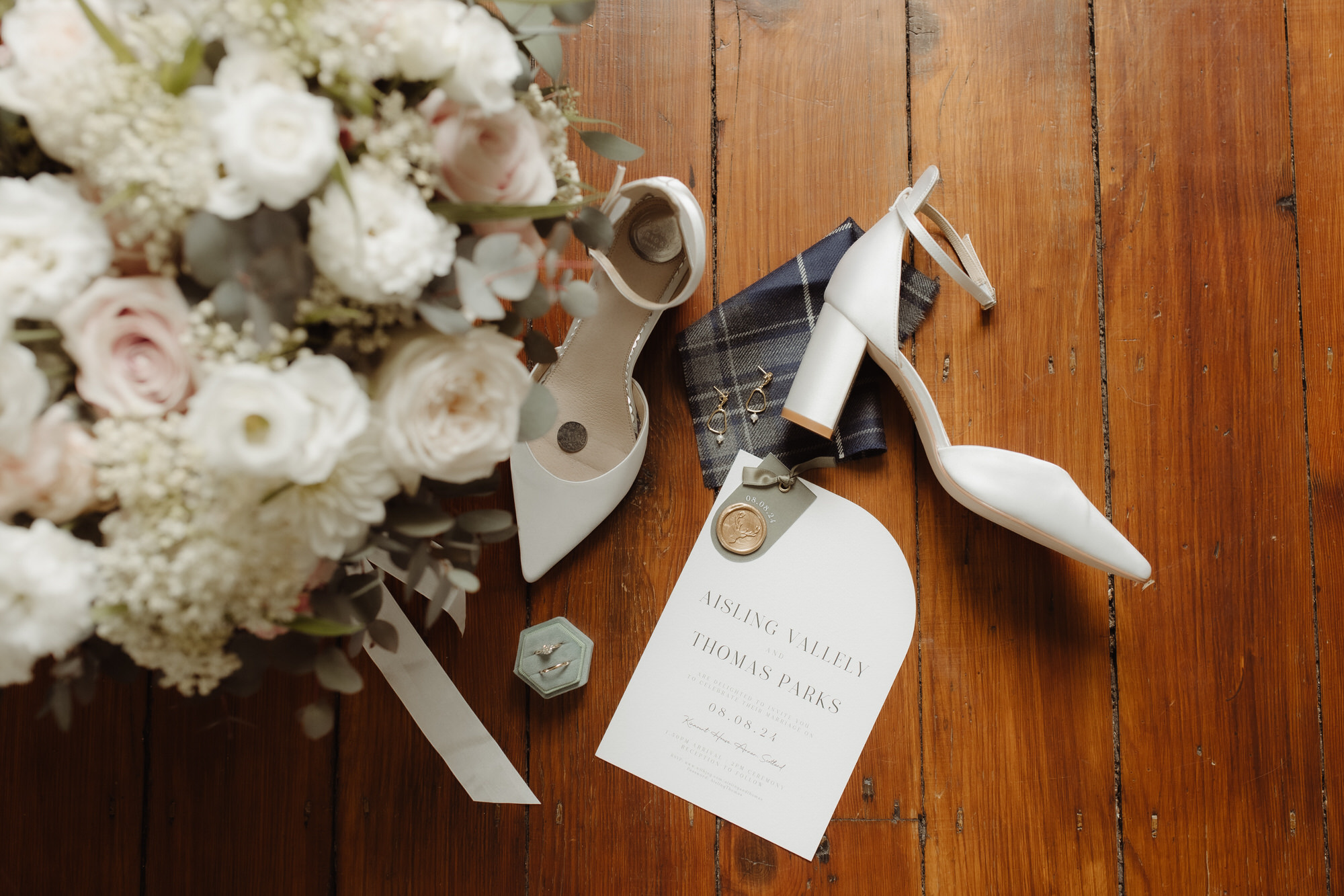 Bridal shoes and flowers arranged on the floor at Kinmount House wedding.