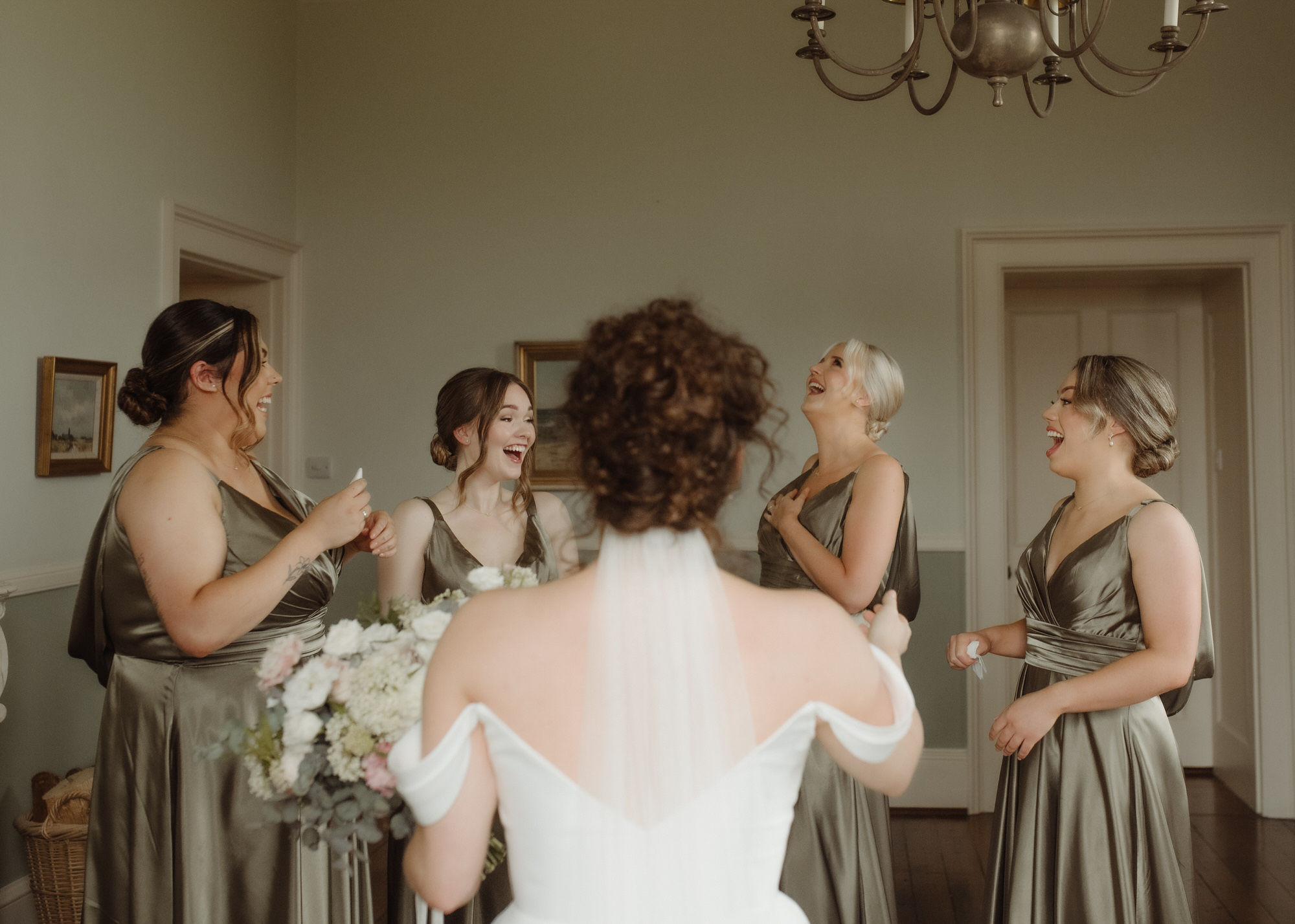 Bridesmaids in olive green laugh at Kinmount House wedding