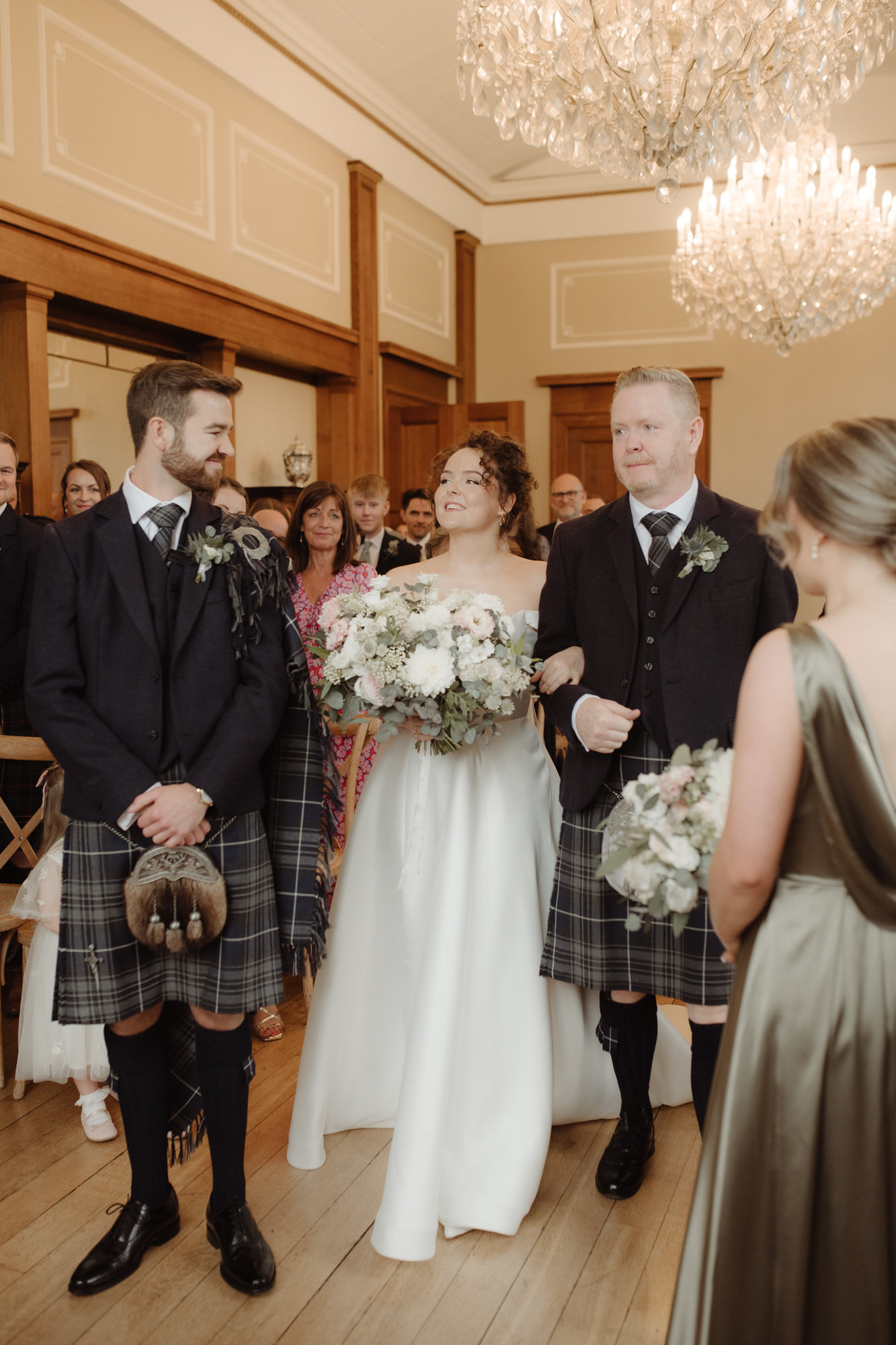 Bride enters the ceremony room and smiles at the Groom at Kinmount House wedding