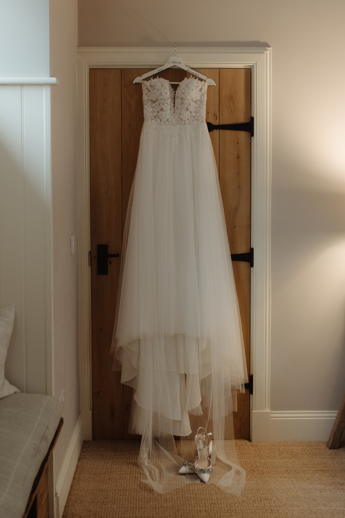 Wedding dress hangs on back of wooden at the Byre at Inchyra.