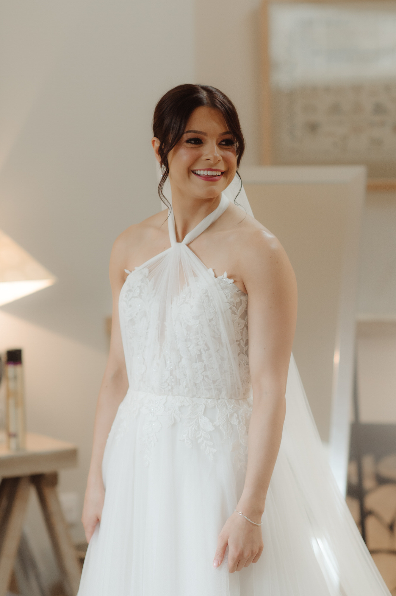 Bride stands and smiles in her wedding dress at the Byre at Inchyra.