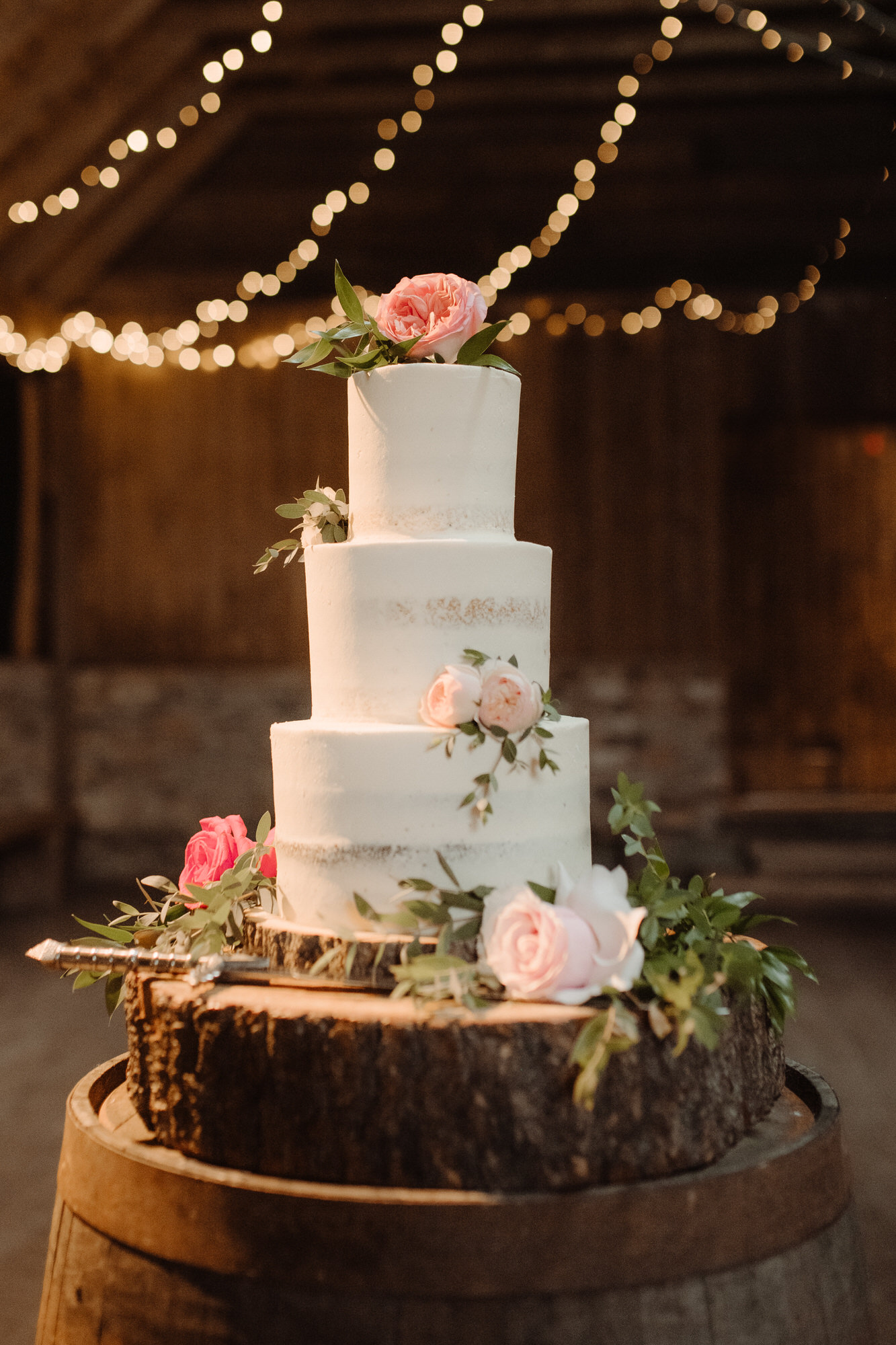 Three tiered white wedding cake with roses at the Byre at Inchyra.