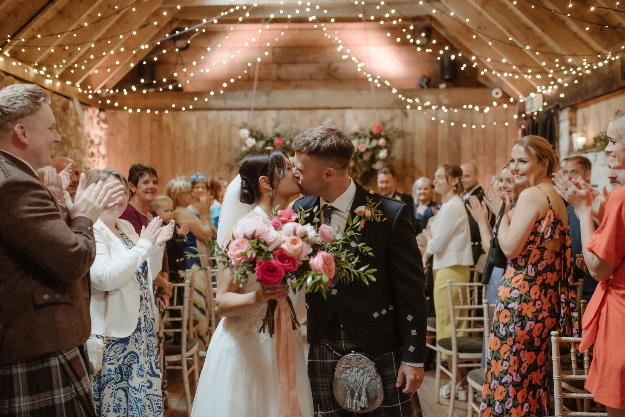 Wedding couple kiss in the aisle at the Byre at Inchyra.