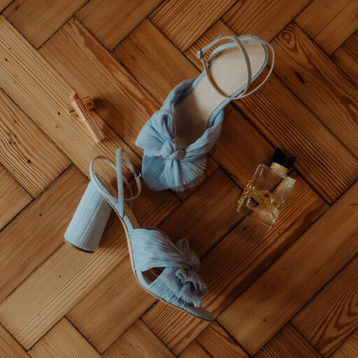 Blue wedding shoes, perfume and lipstick lie on an Edinburgh parquet floor.