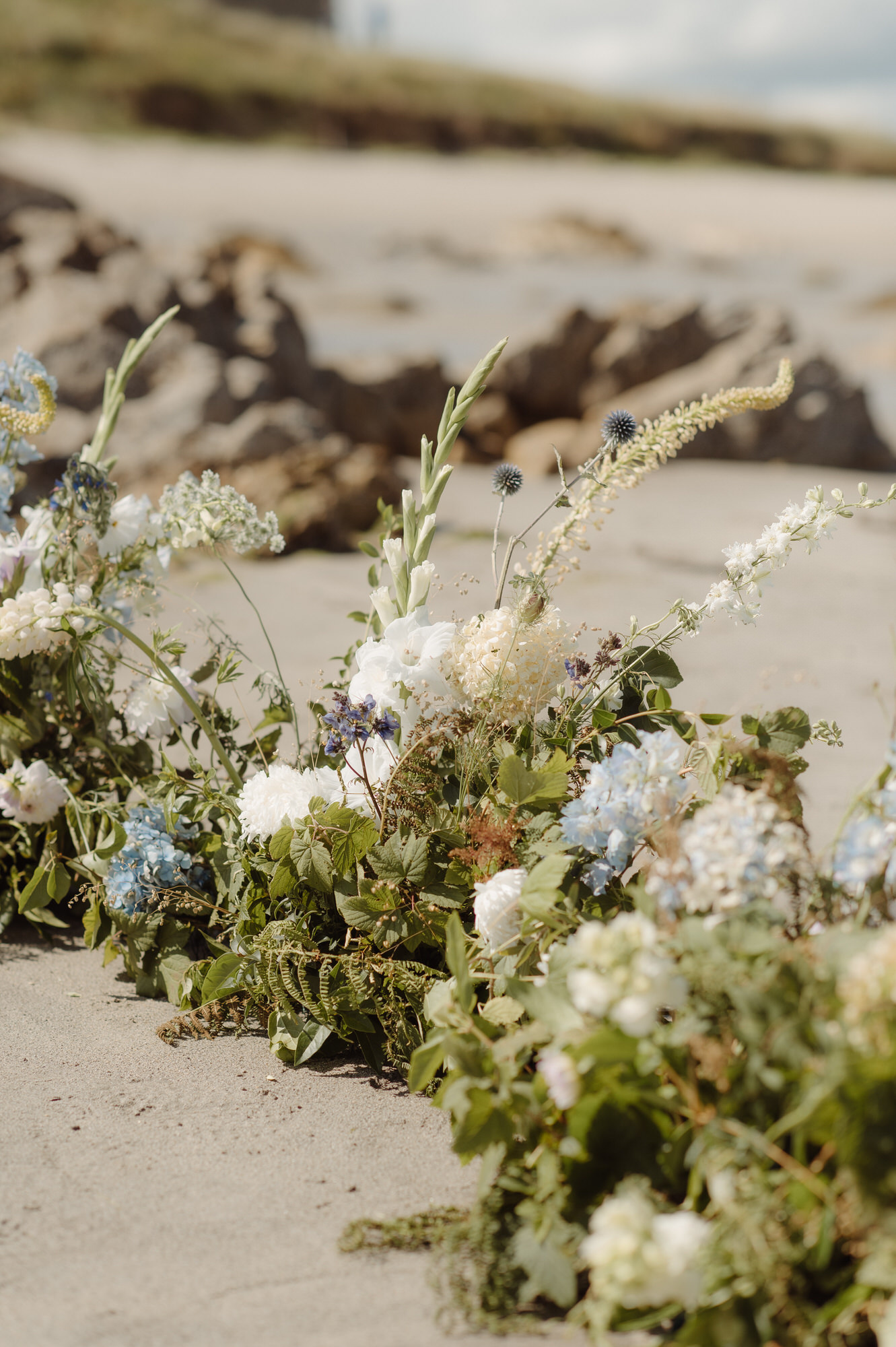 Floral bouquet display on a beach.