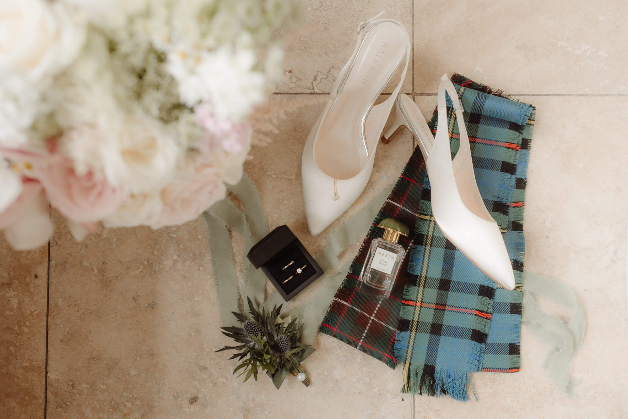 Bridal shoes, ring and perfume on the tiles at Achnagairn Estate. 