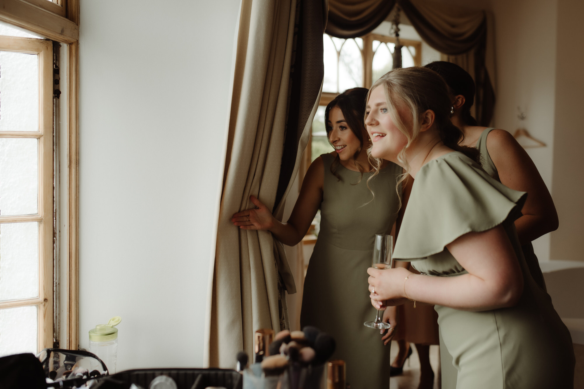 Bridesmaid peek out of a window at Achnagairn Castle.