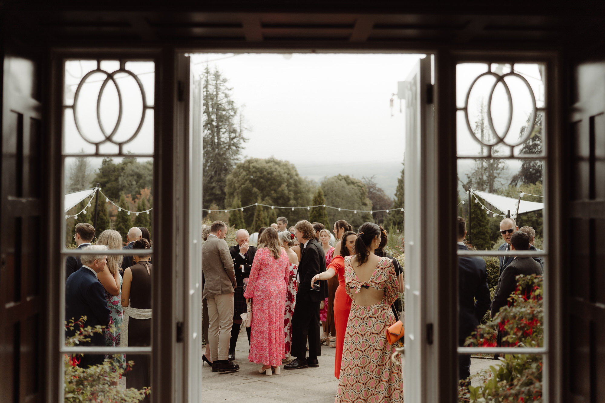 Wedding guests gather on the terrace at Achnagairn Castle.