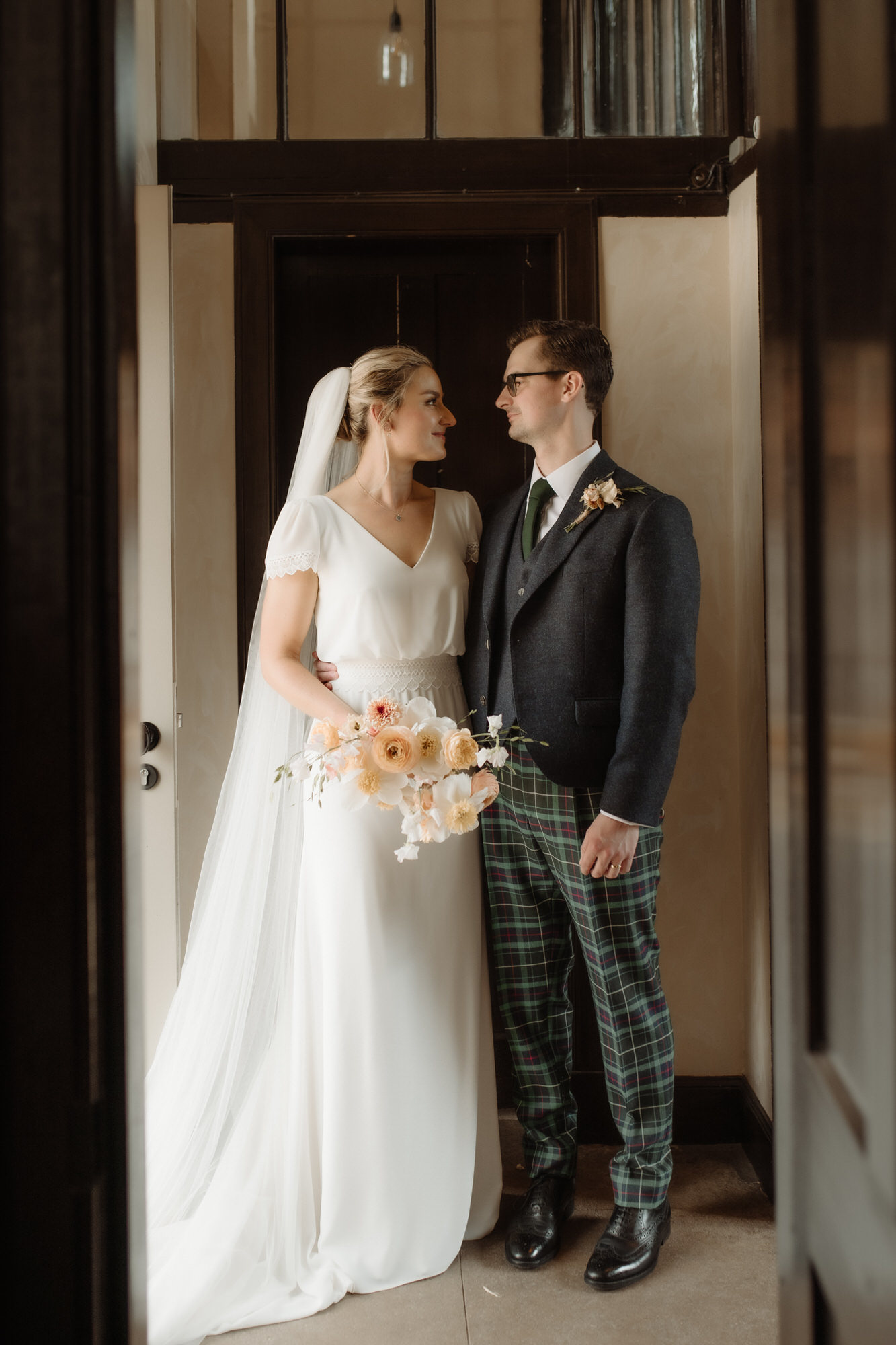 Bride and groom stand in the doorway together. 