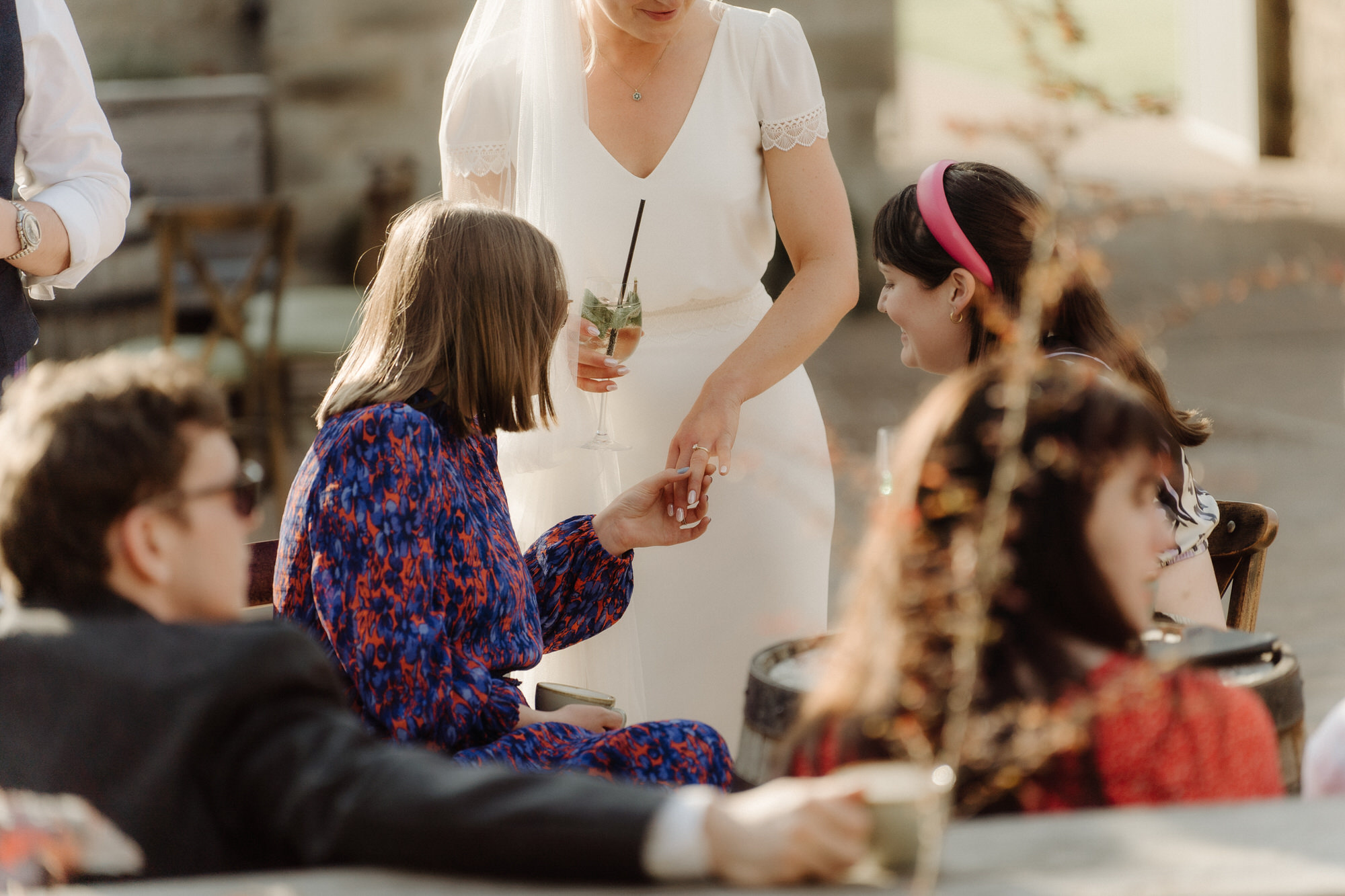 Bride shows friend her wedding ring.