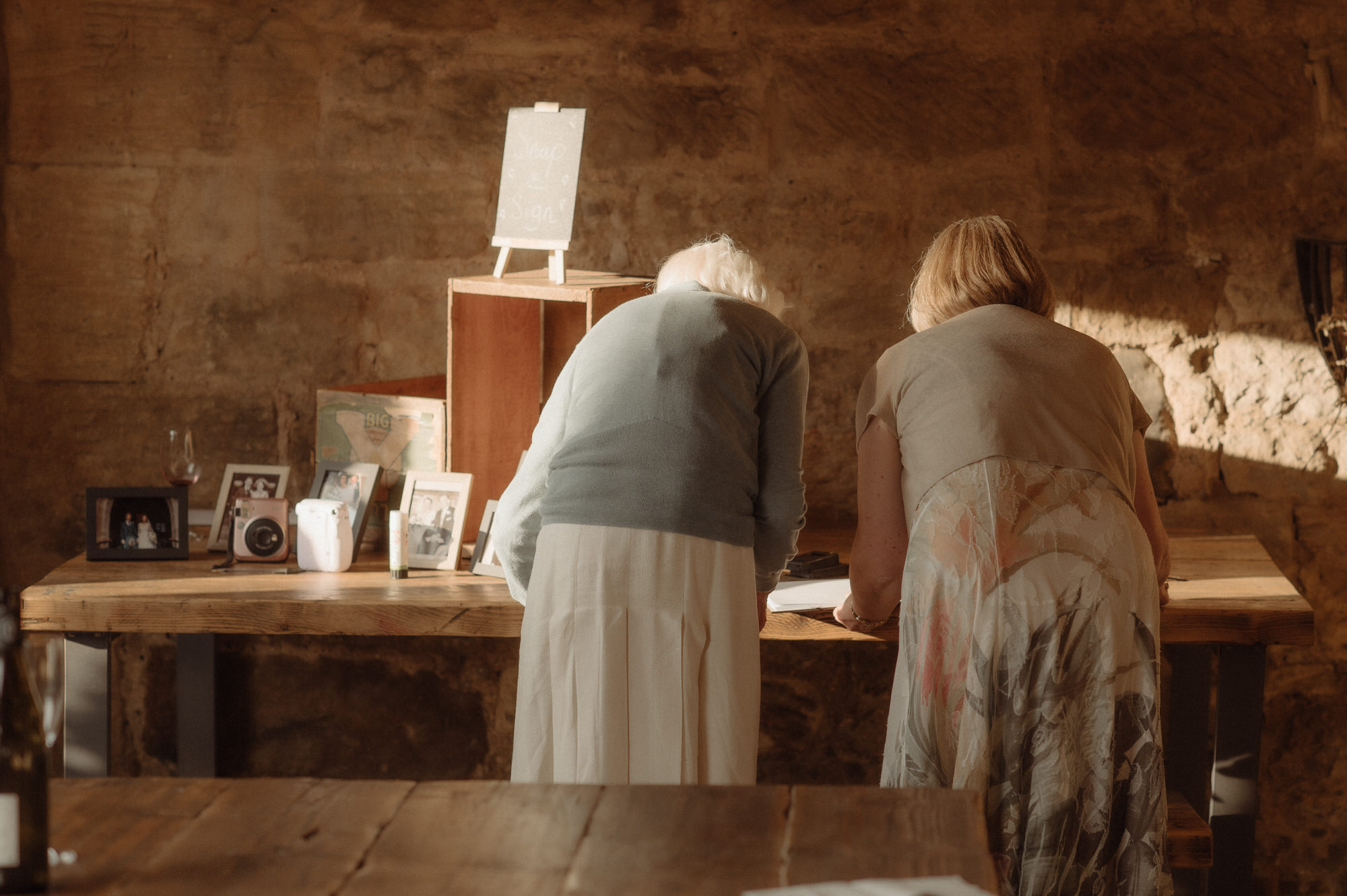 Two women look at a wedding guestbook.