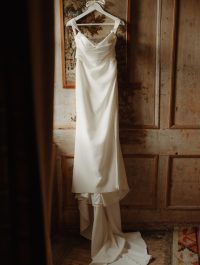 Wedding dress hangs by the window at Neidpath Castle. Wedding & Elopement Photographer in Scotland.